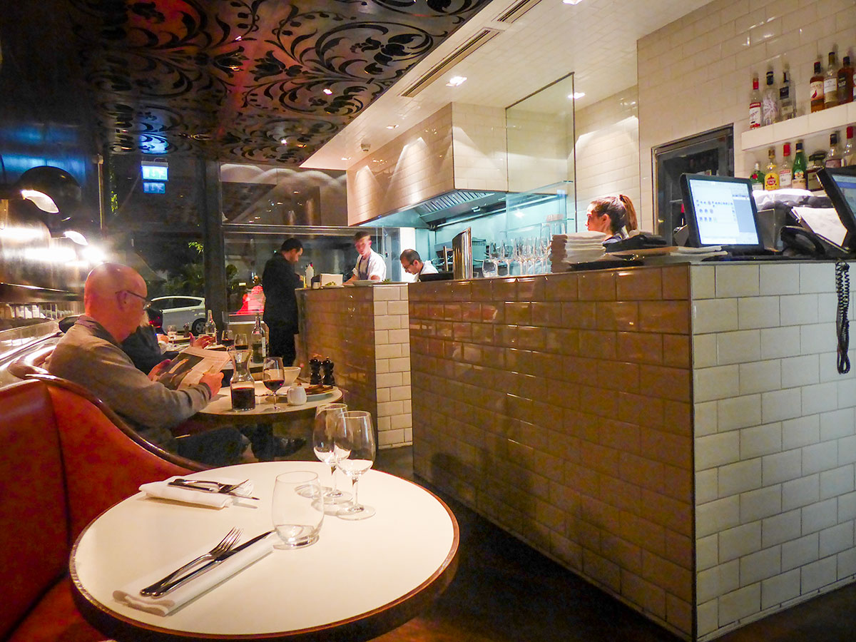 The front part of Hereford Road Restaurant in Notting Hill has cozy leather booths facing the open kitchen.