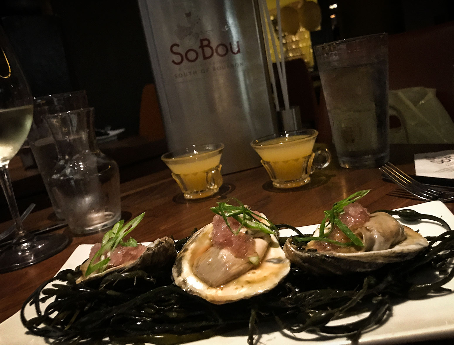 Smoky oysters en escabeche -- with a bottle of hooch in the background at SoBou restaurant in New Orleans