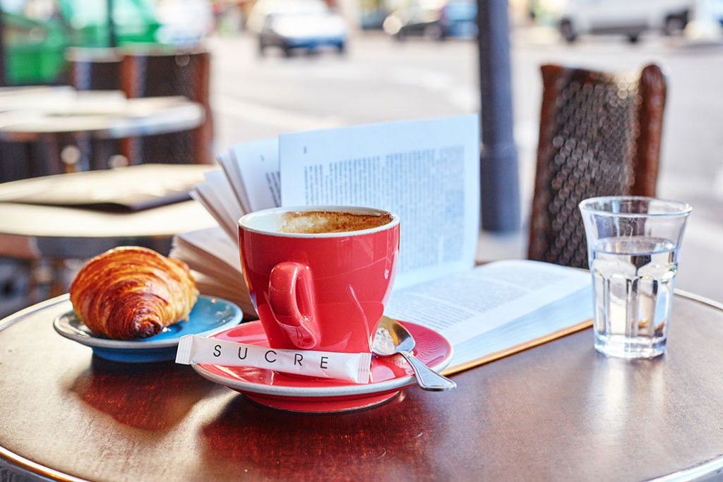 Coffee and a book at a sidewalk cafe in Paris